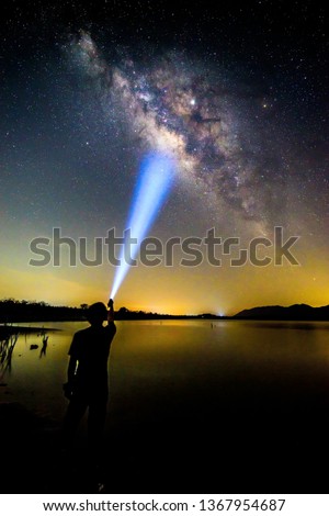 The man Shining the torch to milky way / Milky way with lighting