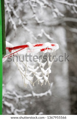 basketball basket with white snow on outdoor winter background