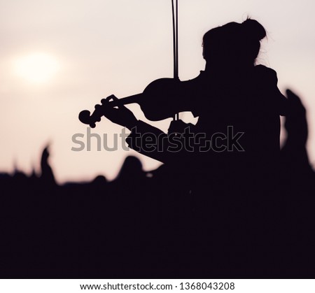 Silhouette of female playing the violin during sunset against the sun - Taken in Prague