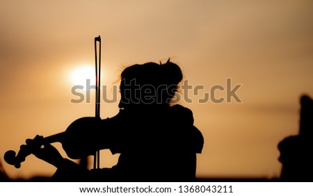 Silhouette of female playing the violin during sunset against the sun - Taken in Prague