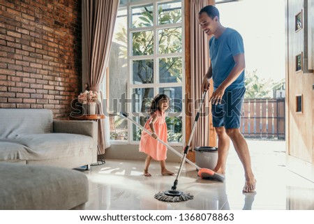 little girl help her daddy to do chores at home Royalty-Free Stock Photo #1368078863