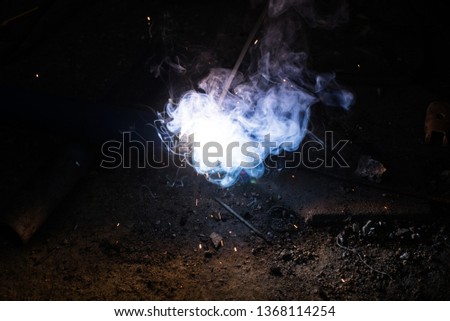 welding steel with sparks lighting in the dark background. 