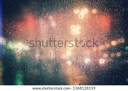 Rain drops on glass with street night lights