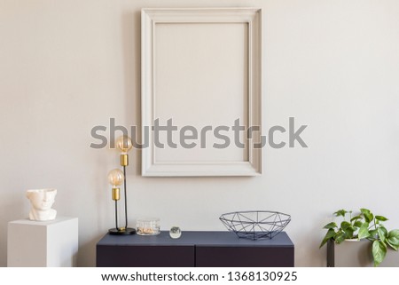 Scandinavian and design home decor with mock up gray poster frame, navy blue shelf with stylish accessories, lamp and plants. Stylish and minimalistic room interior.