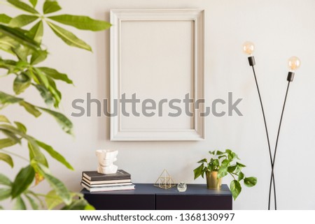 Scandinavian and design home decor with mock up grey poster frame, navy blue shelf with stylish accessories, lamp and plants. Stylish and minimalistic room interior with big plant. Template. Blank. 