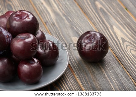Plums fresh organic in crate on wooden table