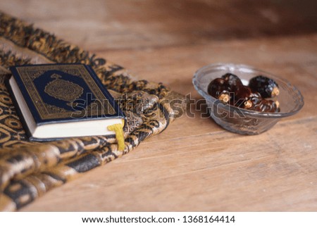 al quran - Muslim holy book with brown cloth and dates with brown wood background - ramadan concept