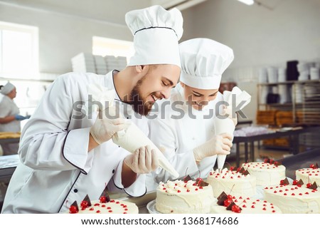 A confectioners squeezes liquid cream from a pastry bag. Royalty-Free Stock Photo #1368174686