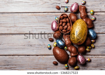 Chocolate easter eggs and bunnies on a rustic wooden background