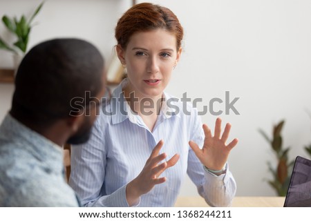 Business woman coach mentor manager consulting client intern, female caucasian insurance broker bank advisor make offer to african customer at meeting sell services talking explaining deal benefits Royalty-Free Stock Photo #1368244211