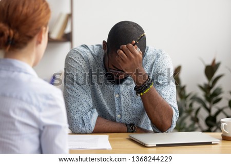Stressed upset african applicant incompetent intern feel afraid disappointed at hiring negotiation, unprepared black candidate depressed about rejection bad first impression on failed job interview Royalty-Free Stock Photo #1368244229