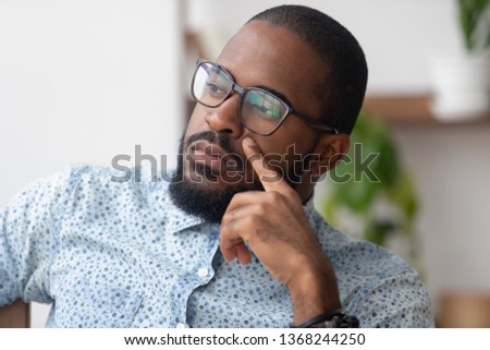 Thinking of solution concept, pensive serious african american businessman looking away deep lost in thoughts, thoughtful dreamy or doubtful black man searching new ideas planning business vision Royalty-Free Stock Photo #1368244250