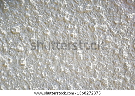 White cement walls have rough surface texture.