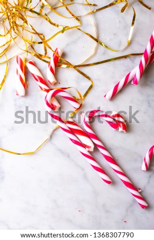 Christmas candy canes and tinsel on a light background