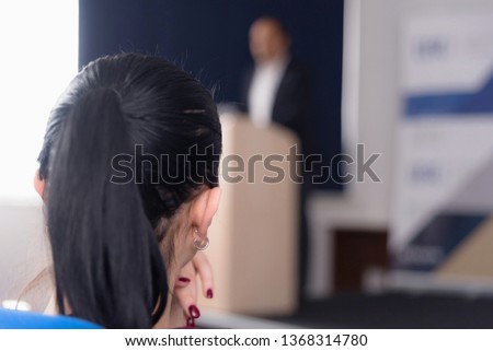 Young business woman listening and watching presentation for business people, multiracial and multiethnic business peoople at conference meeting room.