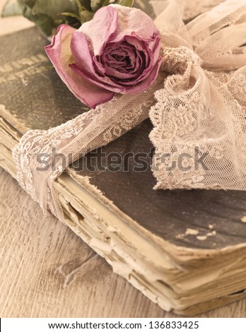 Dry rose on an old book (sepia) Royalty-Free Stock Photo #136833425