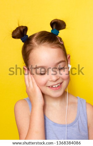 
Little girl in headphones listening to music