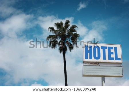 Aged and worn hotel sign with palm tree