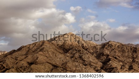 picturesque panorama landscape of dramatic scenic mountain ridge bare sand stone rocks in Middle East Jordan Wadi Rum desert and cloudy sky, geographic and daily planet picture concept