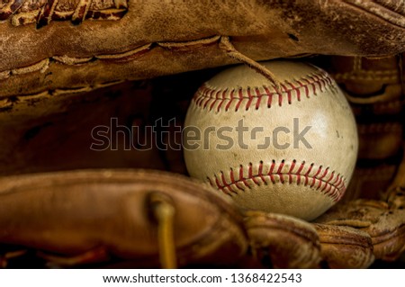 Old Baseball in Worn Leather Glove