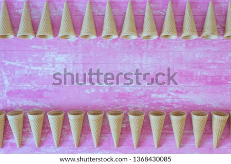 ice cream cones borders on pink wooden background, summer  concept with copy space , flatlay top view