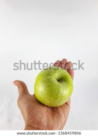 Hands holding Granny Smith Apple in a white background