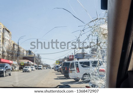 a broken glass background. Frontal window of the car is shattered.