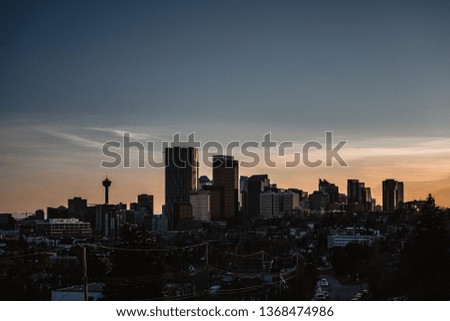 Calgary skyline in the late afternoon with rays from setting sun reflecting off glass buildings.