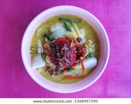 Famous Indonesian food called Lontong. Rice in cube mixed with milky gravy and chicken egg.