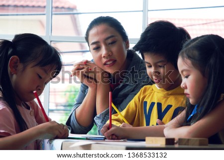 Kids boy and girls learning drawing on white paper in holiday weekend.