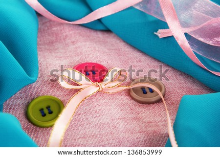 Three buttons on gray  and blue cloth