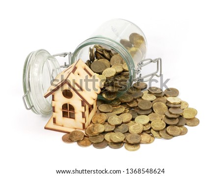 wooden toy house and a pile of coins as an illustration of mortgage or home insurance