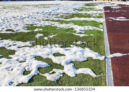 snowdrifts on outdoor soccer field in spring low season