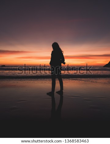 One Woman Photographer Silhouette Standing and Watching Sunset on Beach - Ocean Beach San Francisco California USA