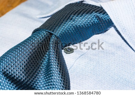 Abstract and conceptual of blu shirt and blue tie. Displayed on a wooden table.