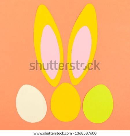 Color eggs and bunny ears on color background. Easter layout
