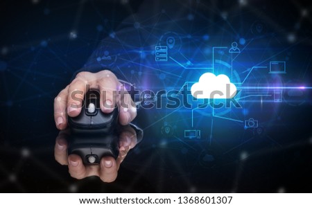 Hand using wireless mouse in a dark environment with cloud technology and online storage concept