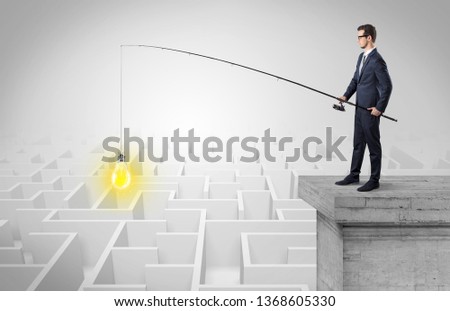 Young businessman fishing new idea concept on the top of a building from a maze
