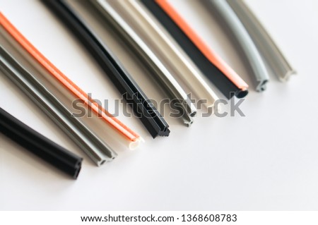 Elastic colored seals for plastic windows and profiles on a white background. Suitable for advertising gaskets and strips for the production of plastic windows or window repair services. Royalty-Free Stock Photo #1368608783