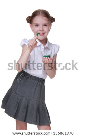 Portrait of beautiful little schoolgirl with paint on Education theme/Lovely schoolgirl wearing uniform and posing with green paint