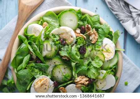 Delicious and simple healthy salad with nuts, eggs and cucumber