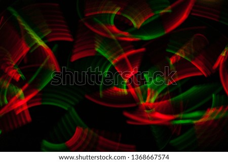 Light painting abstract background. Red and green light painting photography, long exposure, ripples and swirl against a black background. 