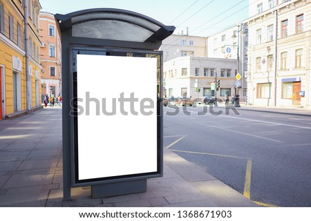 vertical advertising billboard ad in the bus stop. white box for placement in advertising banners. It is located in the city near the road.