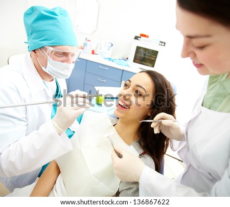 Pretty girl sitting at the dentistÃ?Â¢??s and having mouth checkup