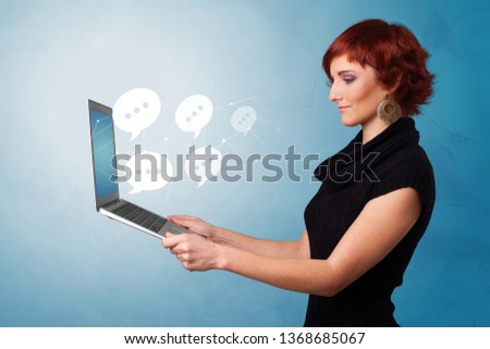 Woman holding laptop with a few speech bubble symbols