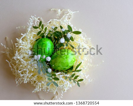 green Easter eggs on pastel background decorated with flowers and leaves. Happy easter! easter greetin card. easter concept