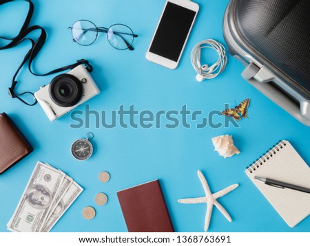 top view travel concept with digital camera, smartphone, map, passport, compass and Outfit of traveler on blue background, Tourist essentials, vintage tone effect