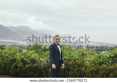 Groom on the background. Portrait of a Young and stylish  groom in green nature. Wedding photo.