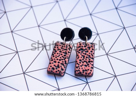 Modern earrings on geometric background. Fashion trendy jewelry.