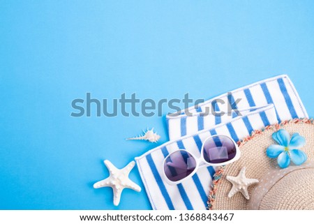 Beach accessories picture frame, sunglasses, starfish, beach hat and sea shell on blue background for summer holiday and vacation concept.